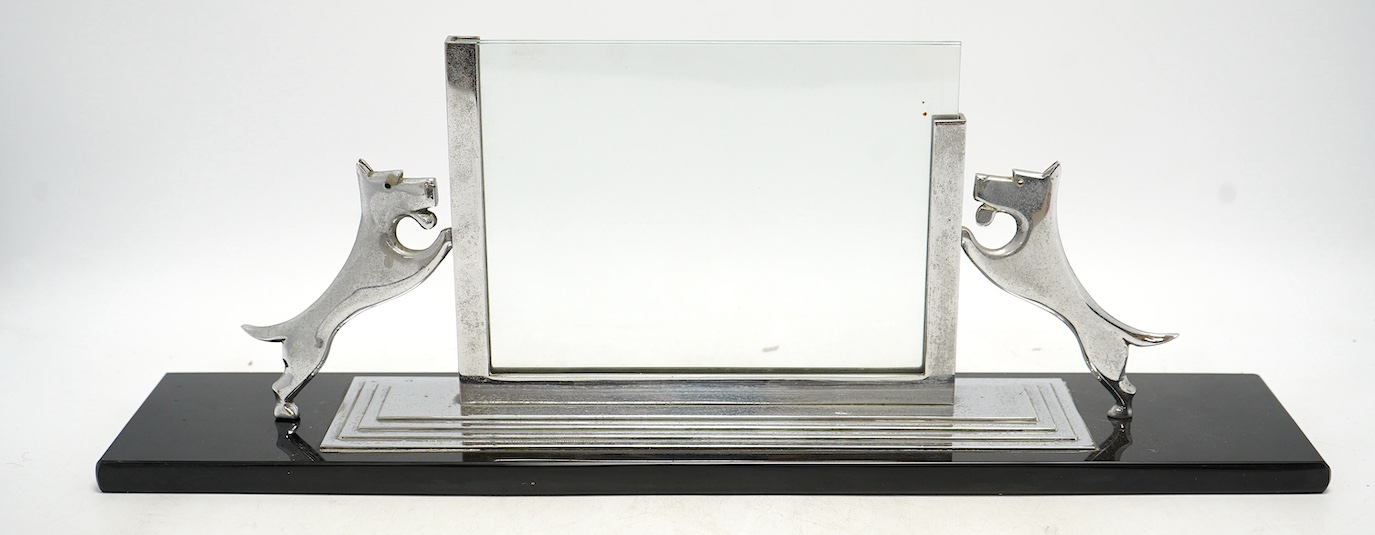 An Art Deco chrome and glass photograph frame on stand, surmounted with two Highland terriers, 48cm wide. Condition - fair